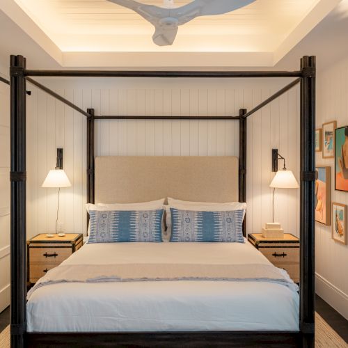 A modern kitchen with a central island, warm wood cabinets, white countertops, and built-in appliances.