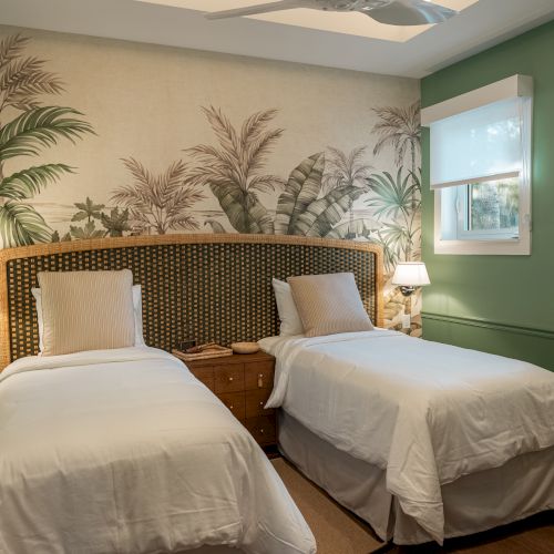 A cozy hotel-style bedroom with two twin beds, warm lighting, a nightstand between, decorative plants, and a soft, inviting atmosphere.